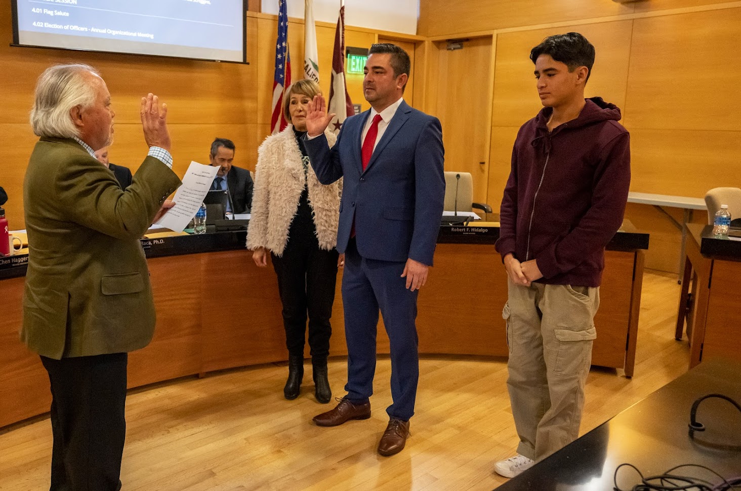 Trustee Robert Hidalgo raises his right hand as he is sworn in for another term.