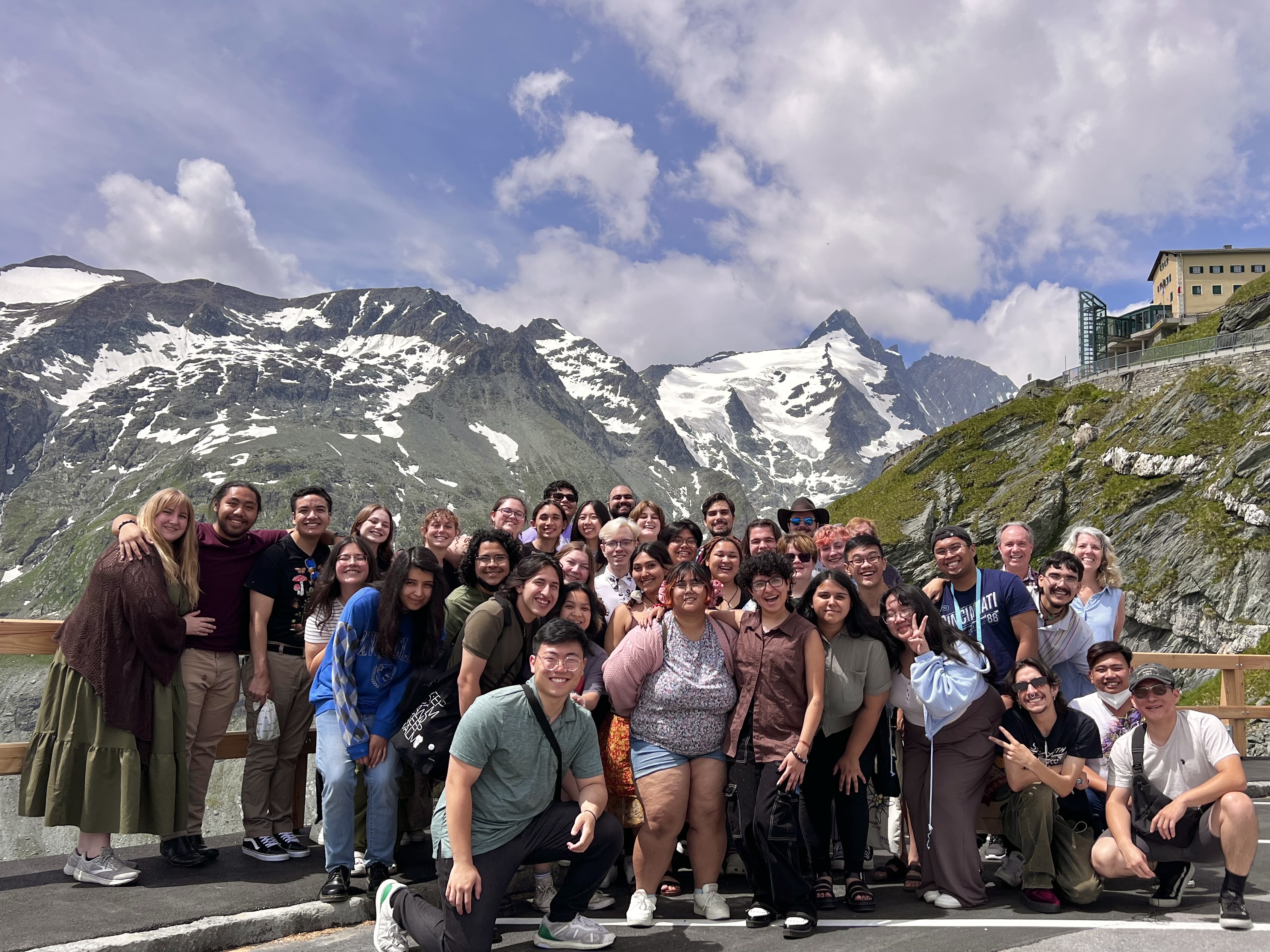 Group of people gathered for photo in front of picturesque mountains.