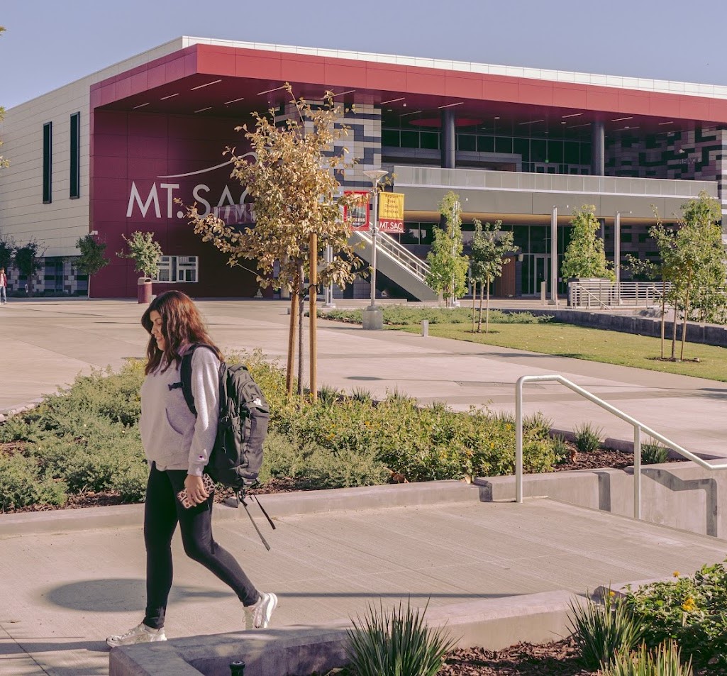 Female student with backpack walking near Student Center