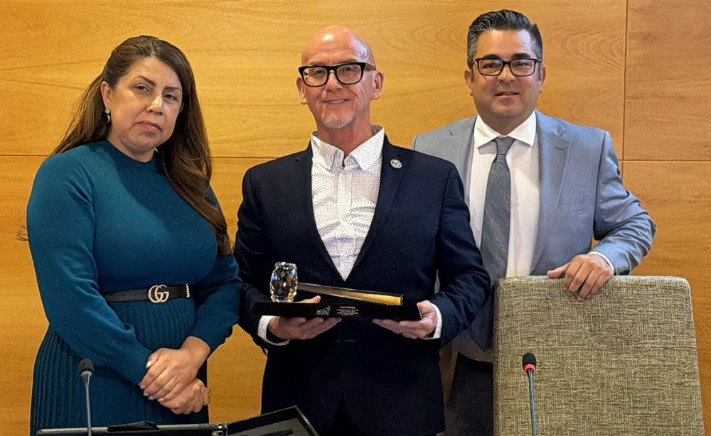 College President Dr. Garcia, outgoing Board President Peter Hidalgo and new Board president Robert Hidalgo are standing together closely and looking at camera.