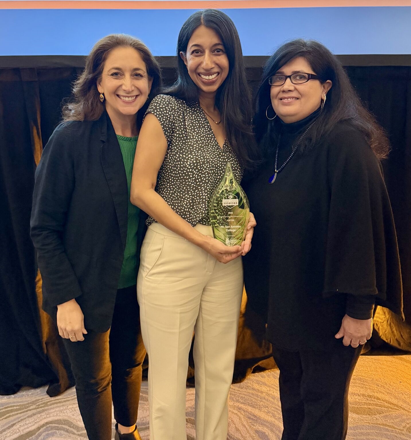 Three women smile at camera