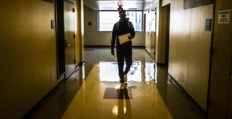 Masked student walking hallway