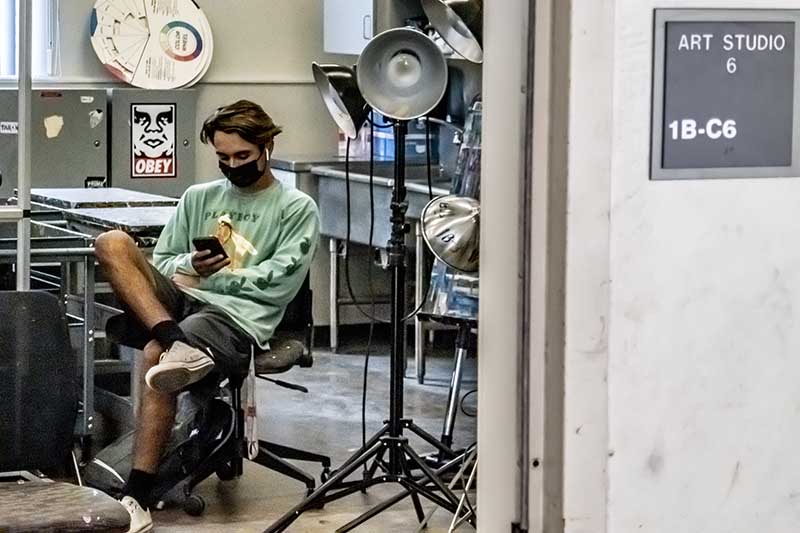 Masked student in art studio