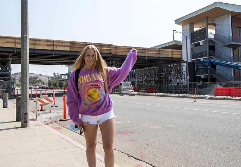 Student points to the pedestrian bridge under construction