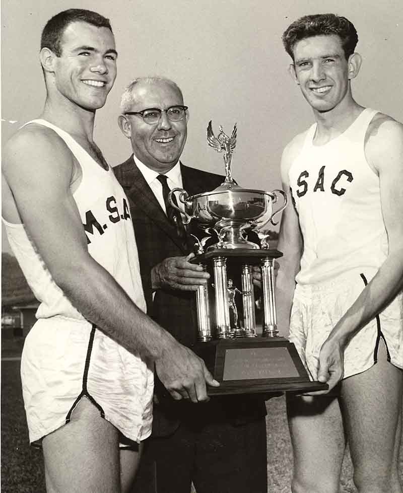 Hilmer Lodge with 2 students holding trophy