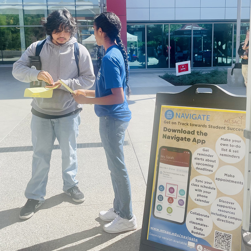 Staff helping student with the app.