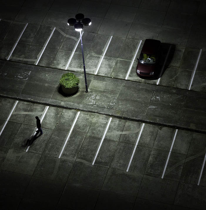 Lone car in parking lot with suspicious person