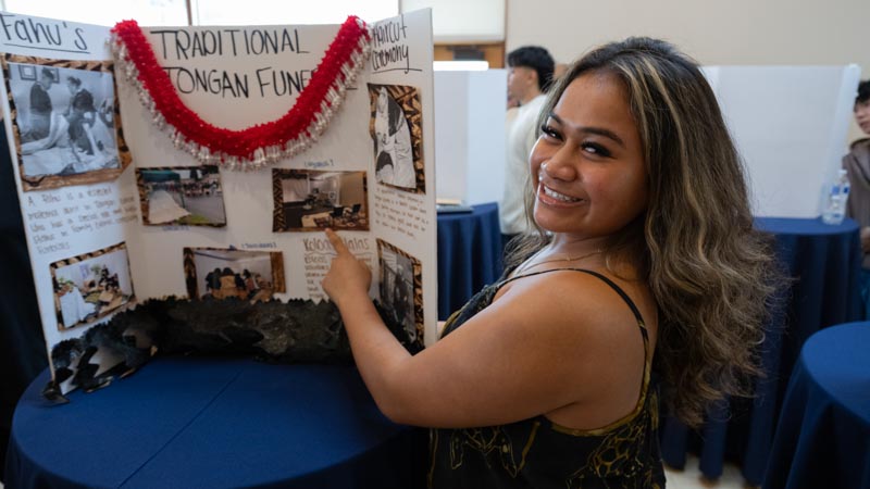 Sela Suliafu shares her museum exhibit about Tongan funeral practices with visitors. 