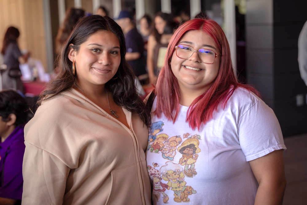 Two students smile