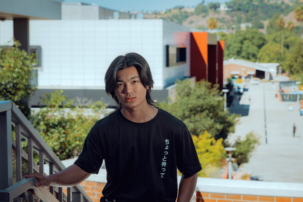 DJ Agbayani walks up the steps of Bldg. 26, with the Student Center prominently in the background.