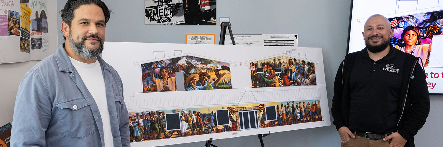 Sergio Robleto (L) and Giovanni Rodriguez (R) flank the mural design
