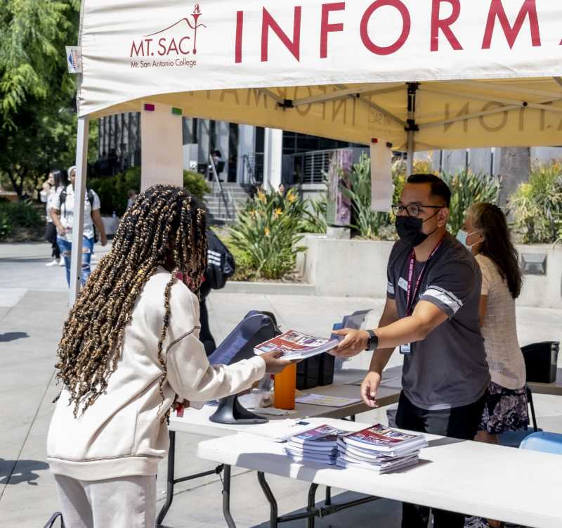 Info booth staff hands out Planner