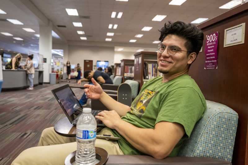 A sutudent on his laptop in the Library