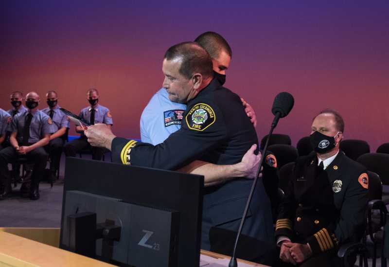 A commander hugs his son who graduated