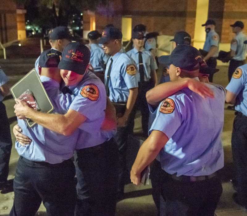 Fire grads hug goodbye to each other 