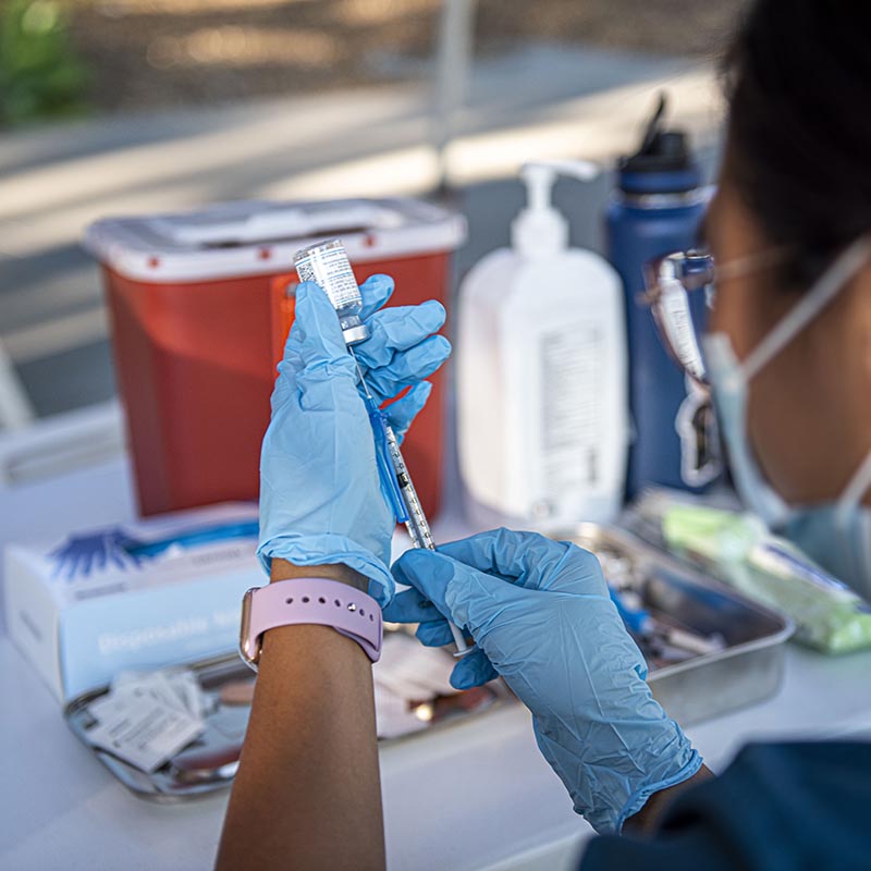 medical worker draws a vaccine dose