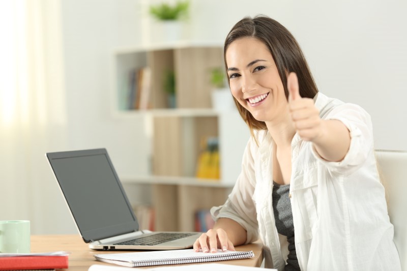 Student on laptop giving thumbs up