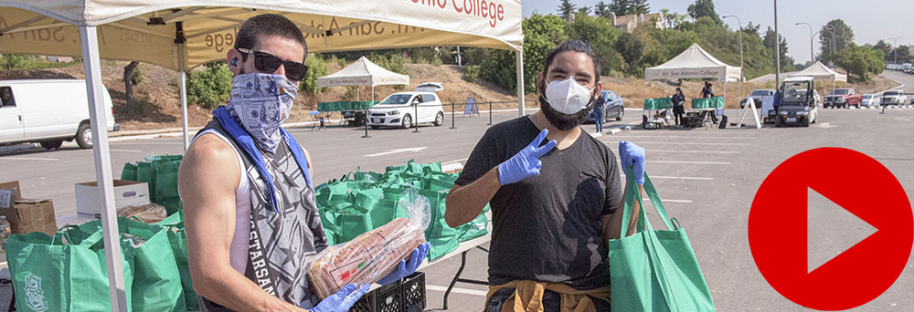 student volunteers hold up pantry bags