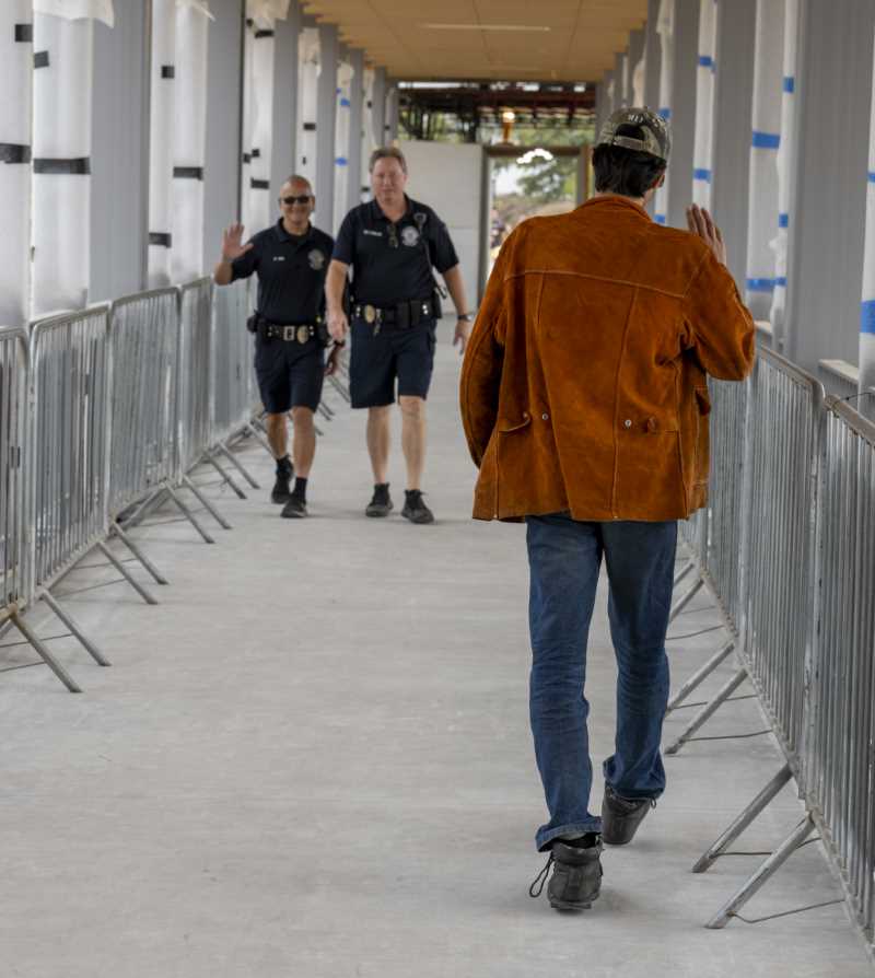 Students waves to campus officers on way over Pedestrian Bridge