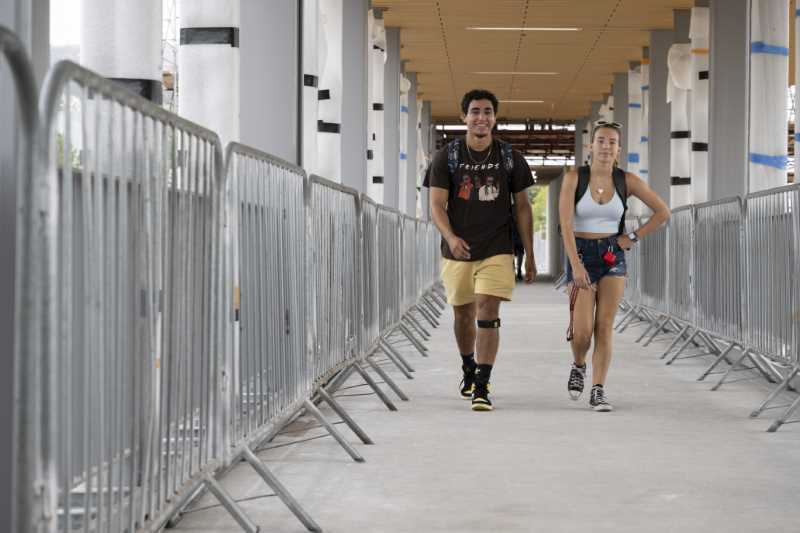 Students walk across the Pedestrian Bridge