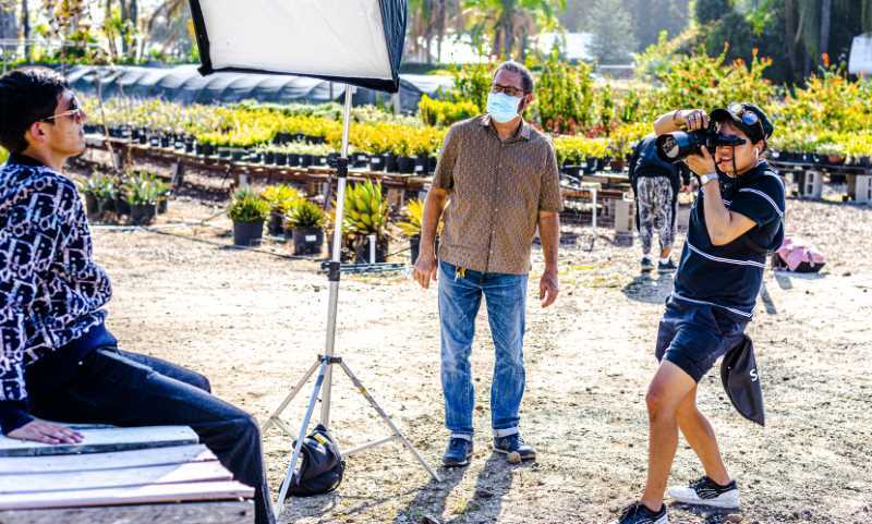 Photography Club student shoots a Fashion Club student with Professor Jay P. Morgan looking on