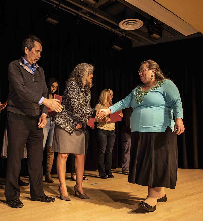 A student receives her certificate