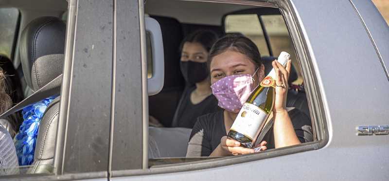 student holds up sparkling cider