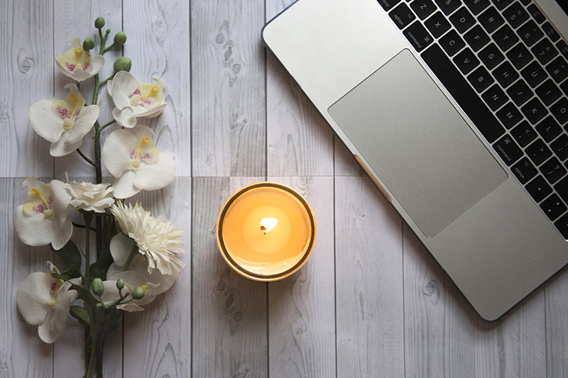 Candle, flowers and laptop