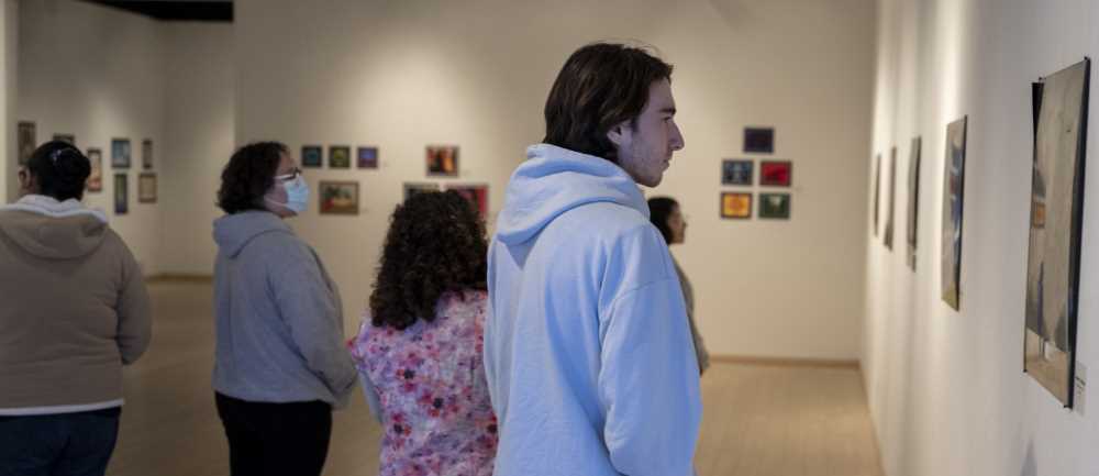 Students viewing art exhibit in gallery