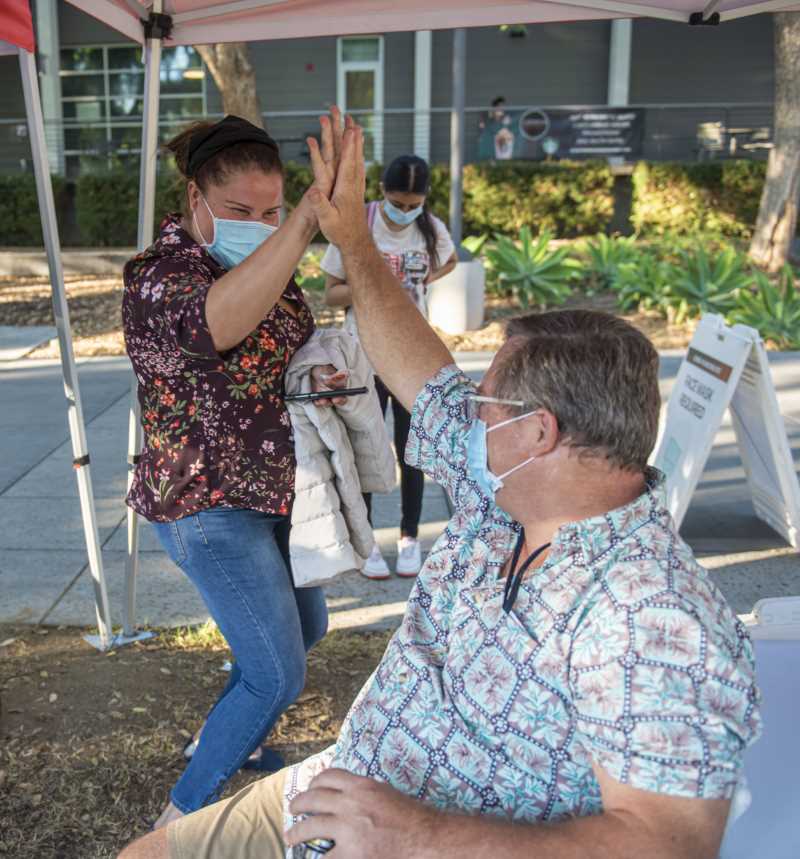 woman and man high five after being vaccinated