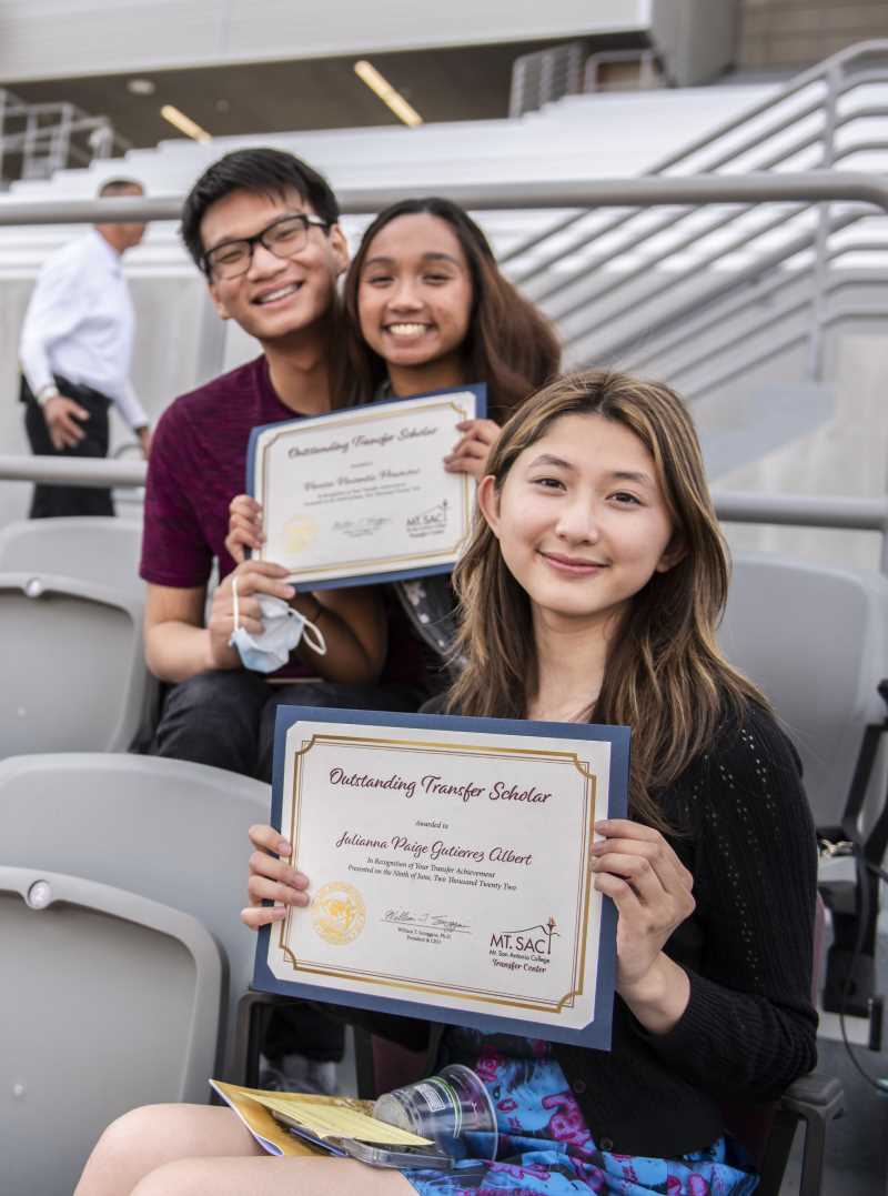 Students hold up their "Outstanding Transfer Scholar" certificates. 