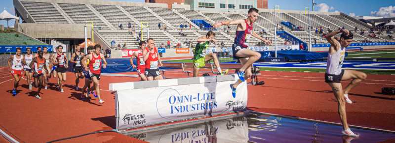 Male runners jump hurdle into water - courtesy of Mt. SAC Relays Photographer