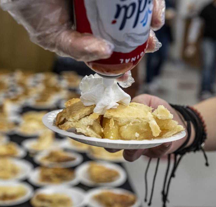 Whip cream being sprayed on pie