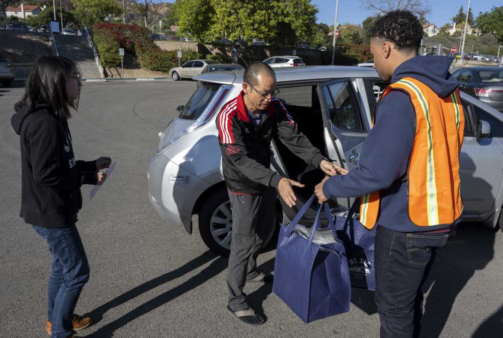 Student worker gives out holiday meal to student 