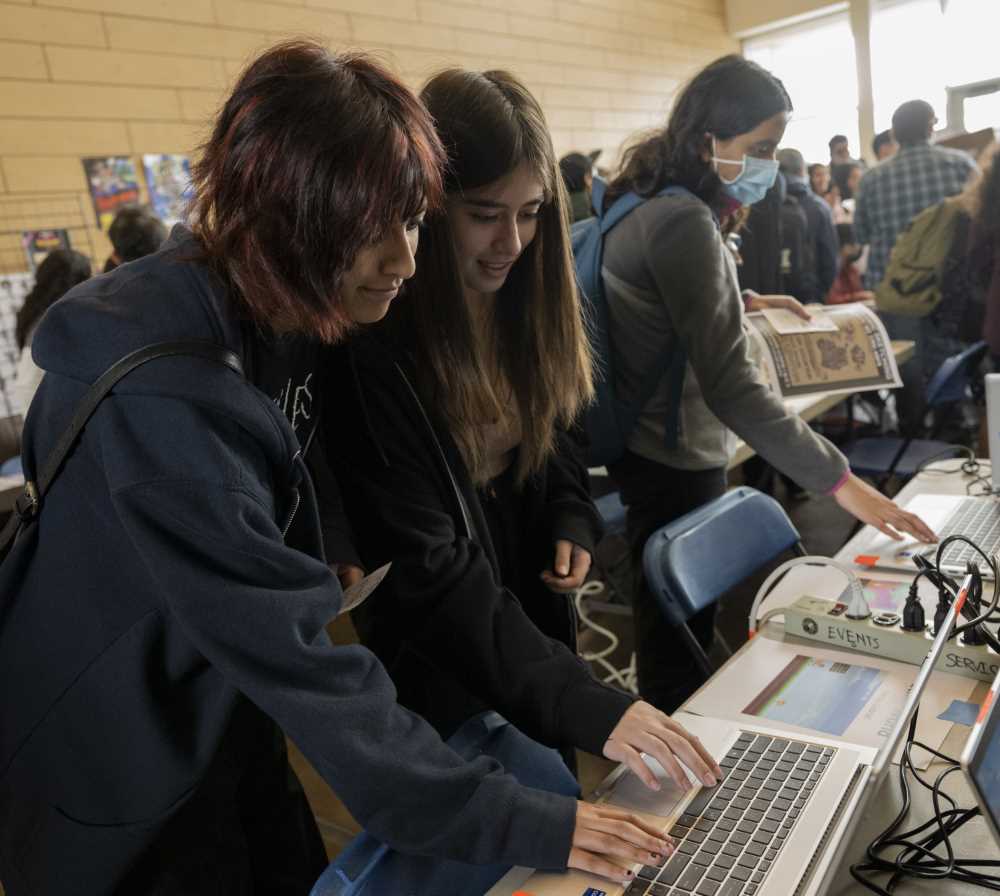 Student attendees play a video game on laptop