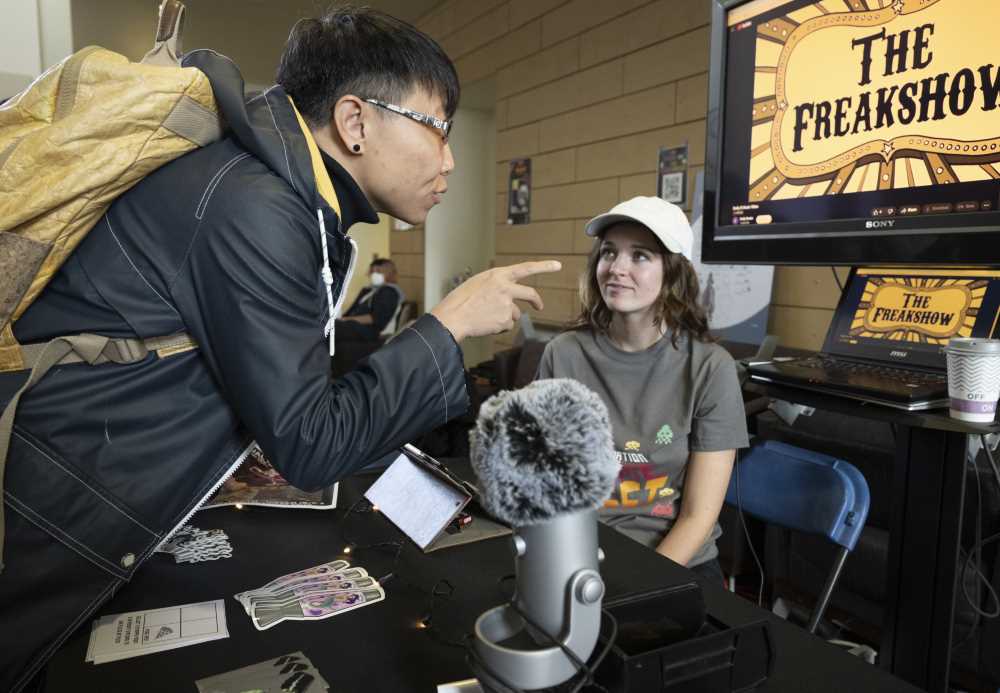 Attendee asks a student about the Radio program