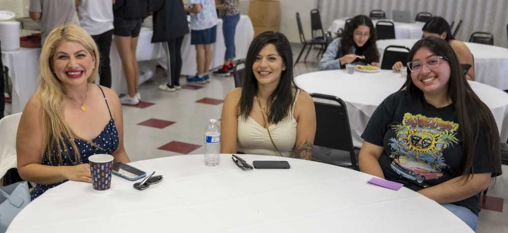 Dr. Terry Reyes sits and talks with students