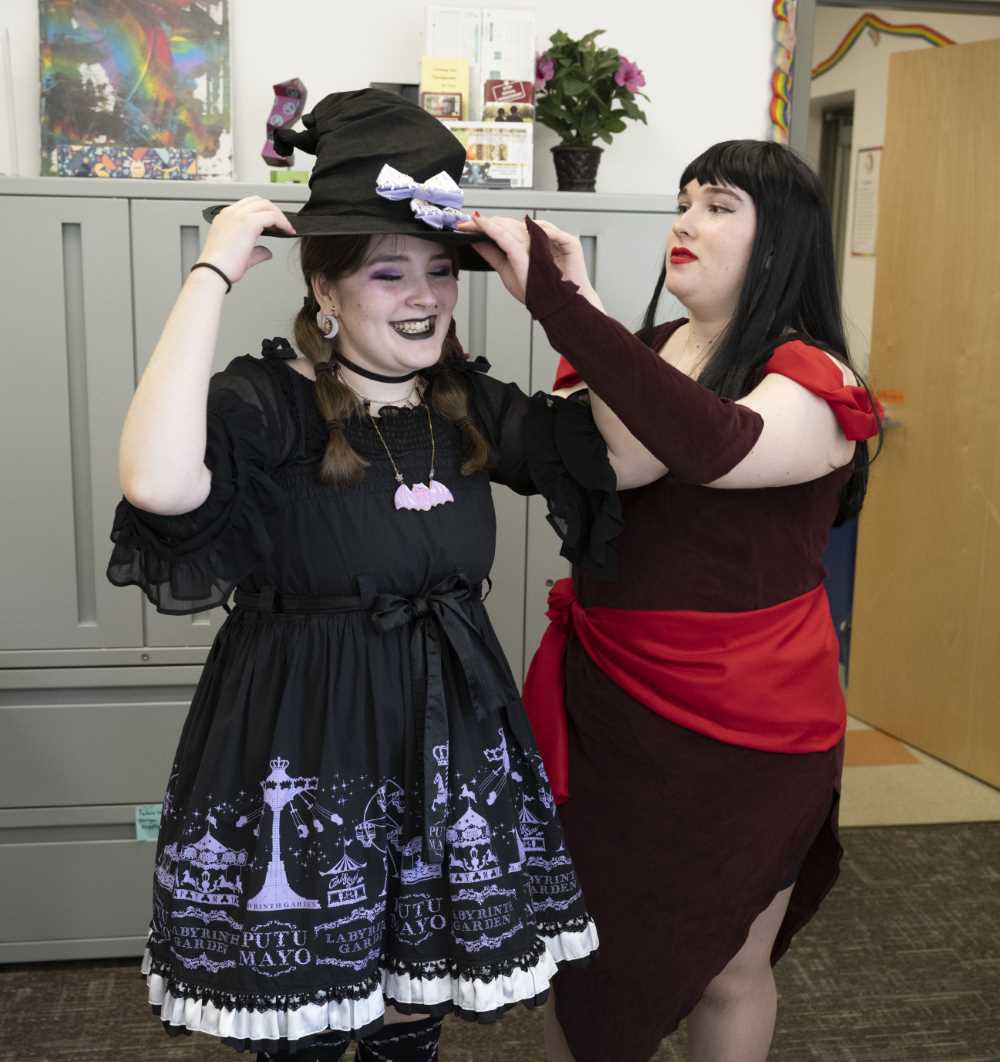 Student helps another student with their costume