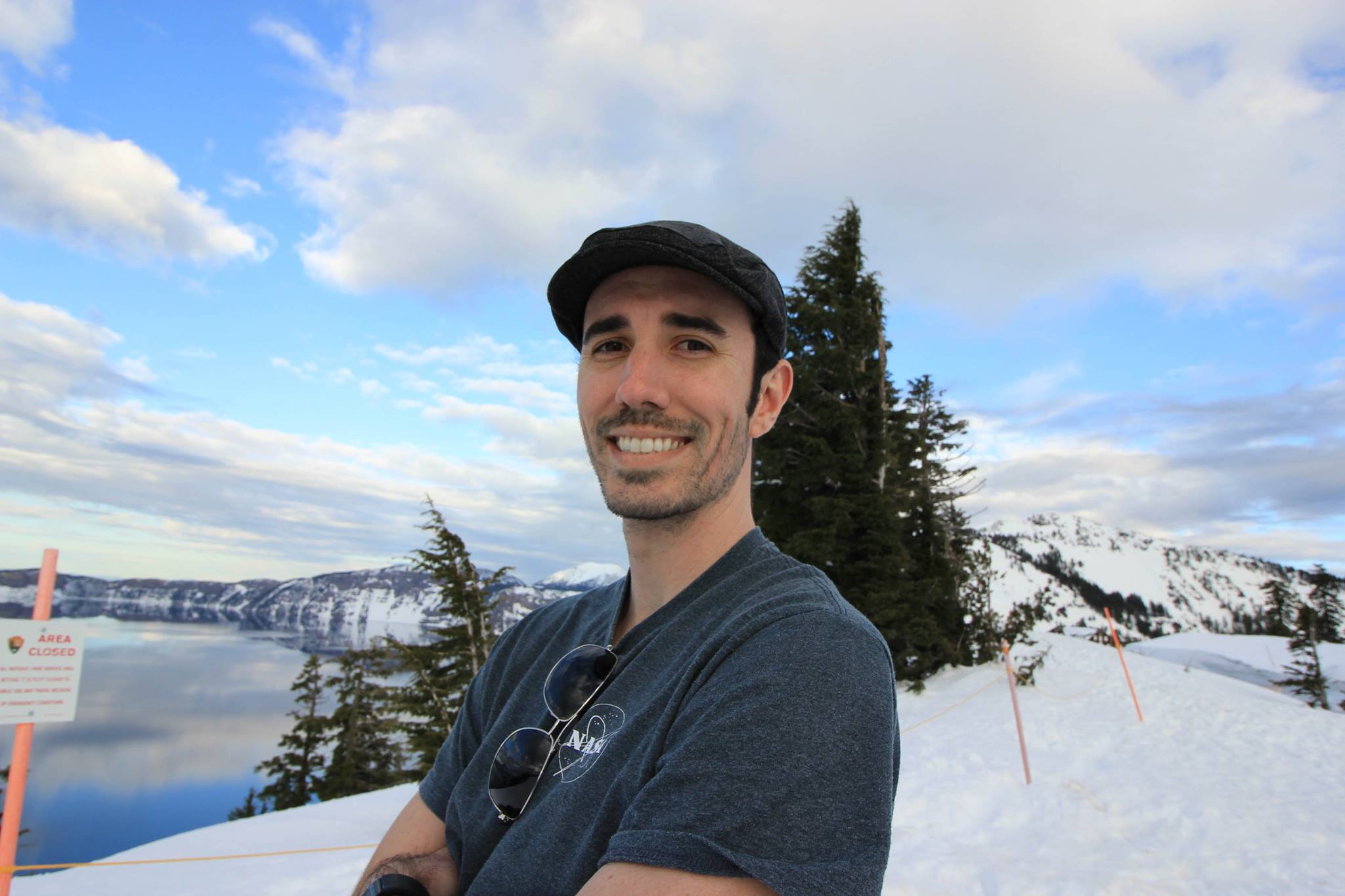 Prof. Brandon Saller stands in front of snow-covered mountains