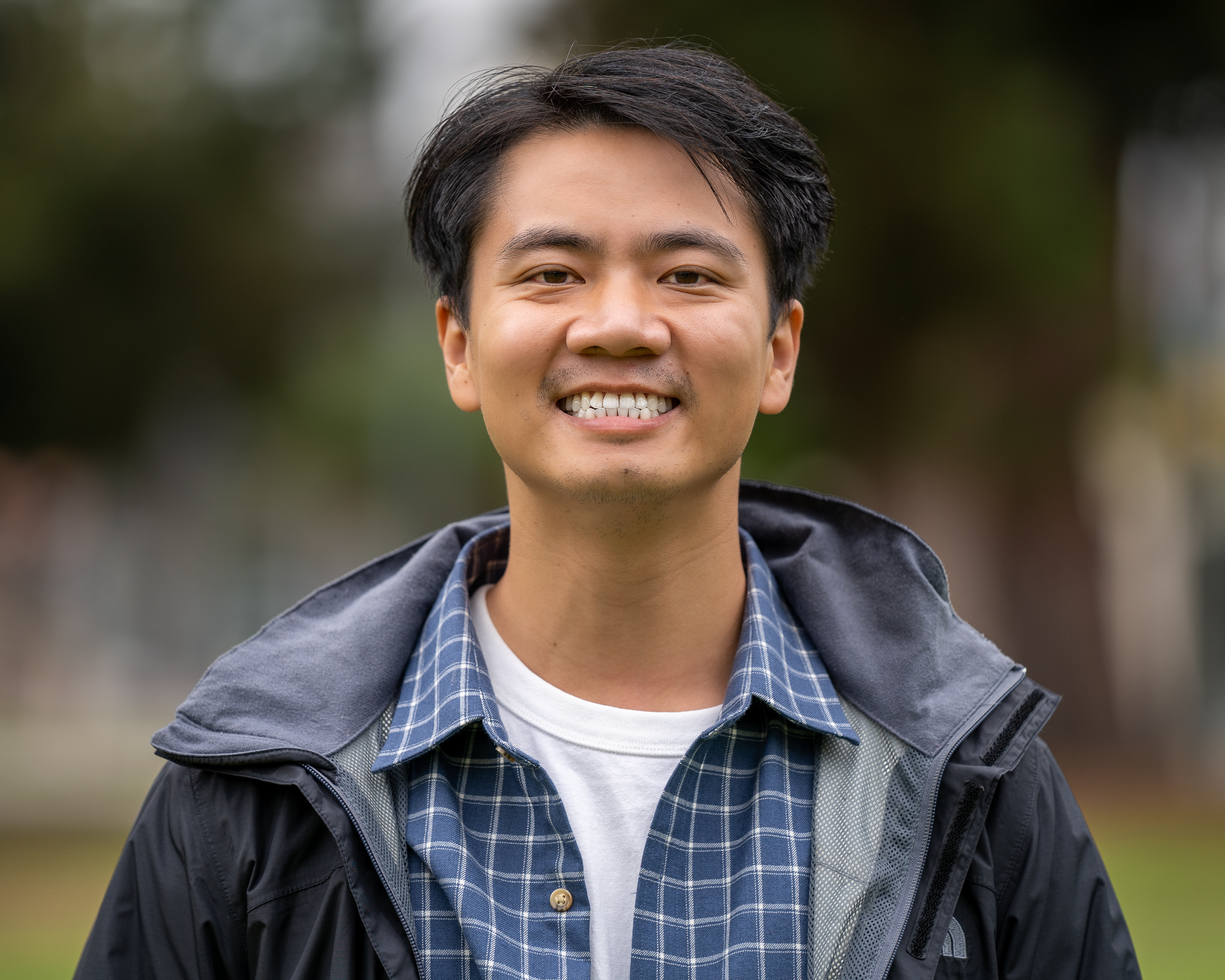 Kevin Liu looking straight ahead with a blue plaid wool shirt and a rain jacket