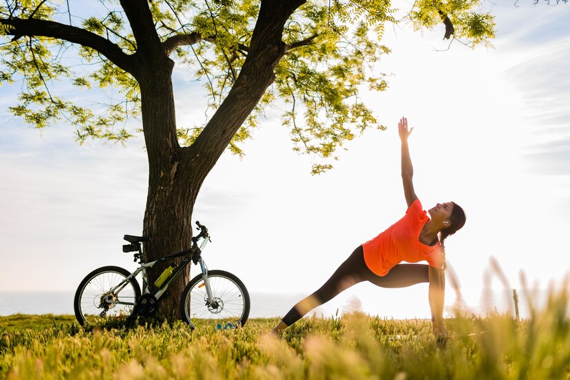 woman stretching outside with bike in background