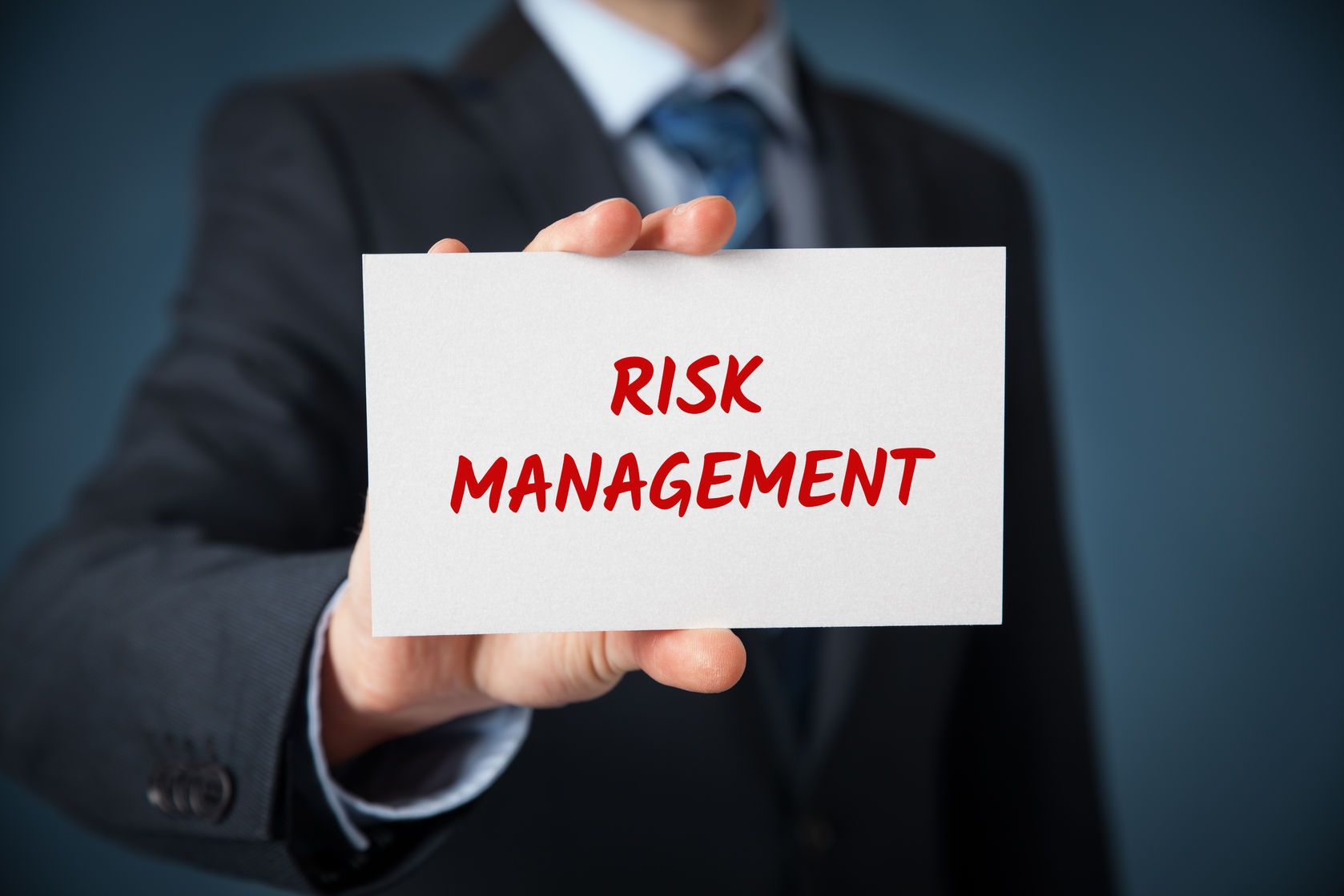 Person holding sign that says Risk Management